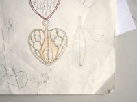 a drawing of a necklace with a heart on it