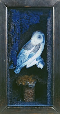 a blue and white owl in a wooden frame